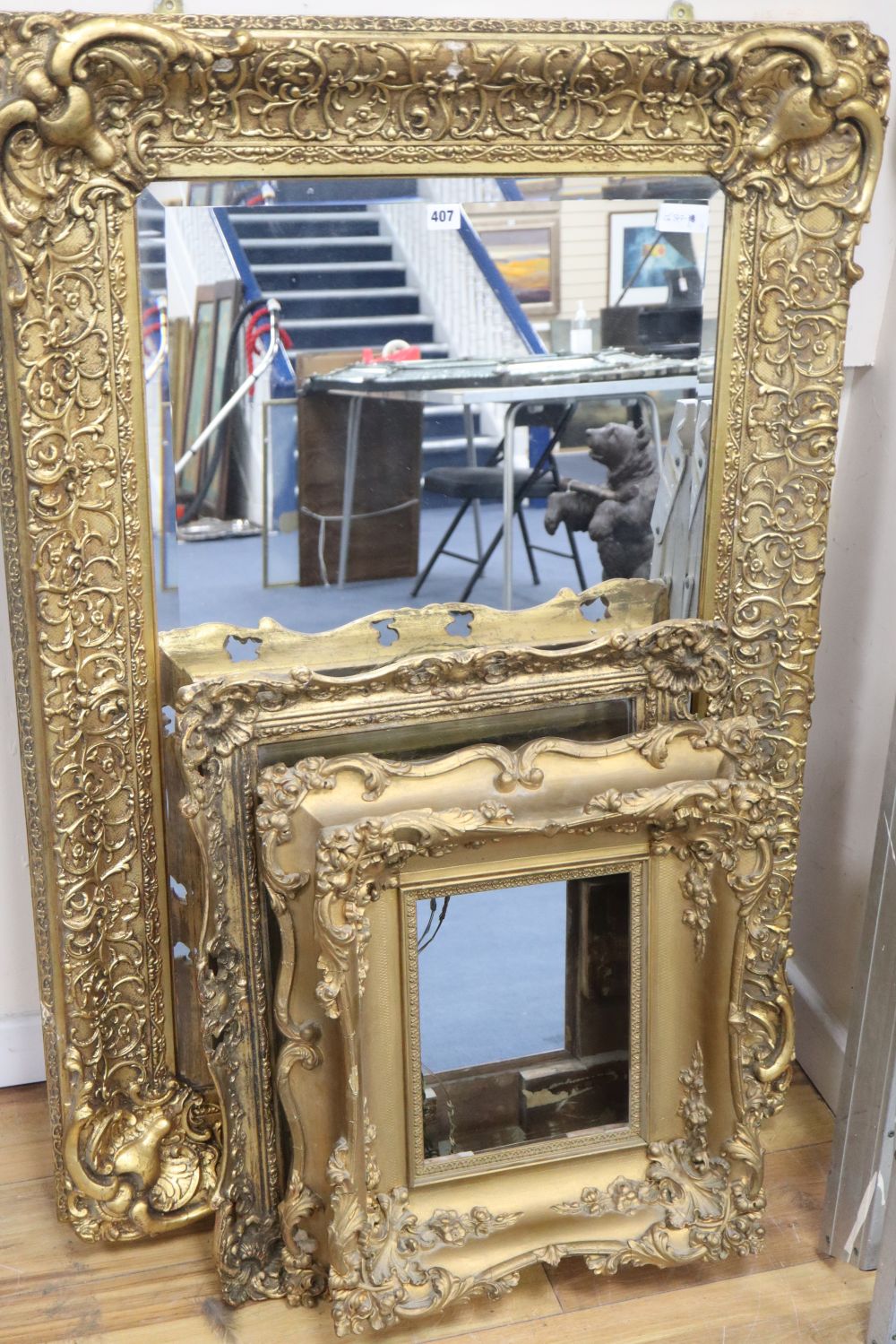 A large reproduction gilt mirror, 123 x 182cm, a similar gilt framed mirror and a gilt picture frame,